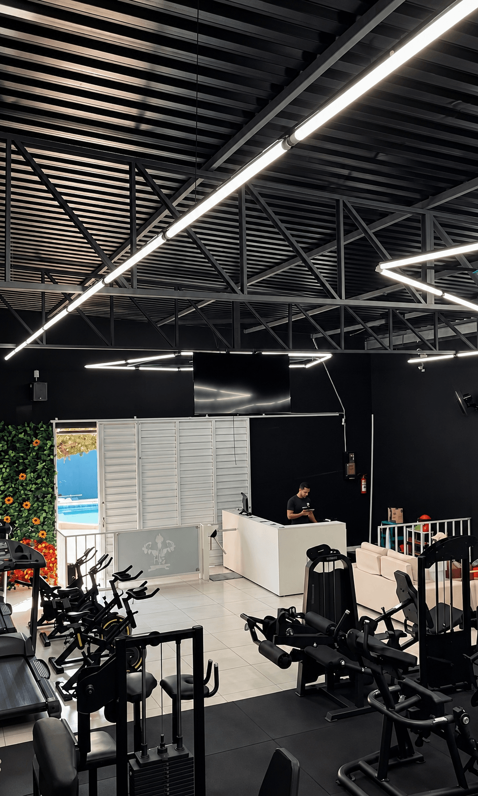 Entrada e recepção reais da Academia Área 51, com equipamentos ao redor